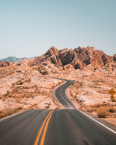 Long winding road with rock formation in the background in the Valley of Fire, Nevada