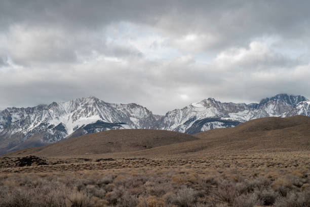 istock brown winter desert valley, hills, snowy mountain peaks 1128513889