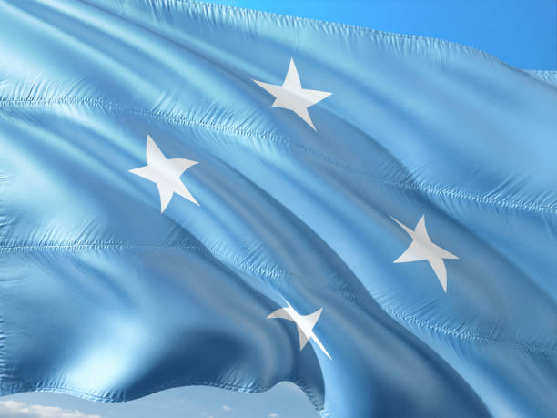 istock Flag of Micronesia waving in the wind against deep blue sky. High quality fabric. 1128517423