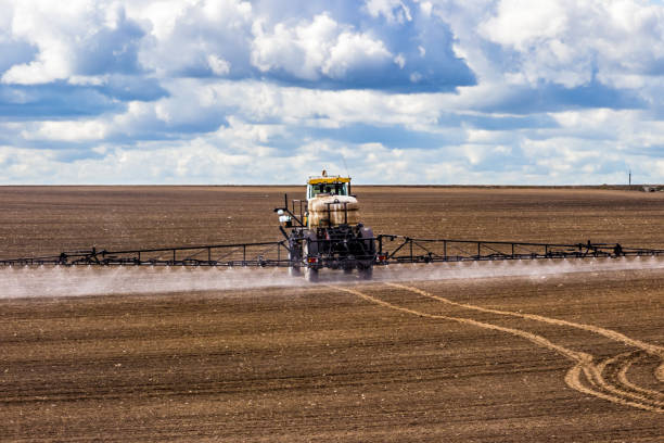 istock tractor spraying a field on farm, fertilizes the land 1128519035