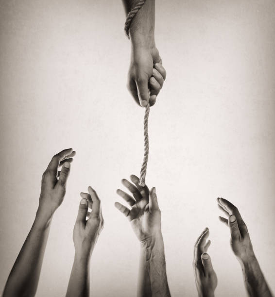 istock Helping hand with rope. Black and white image. 1128519354
