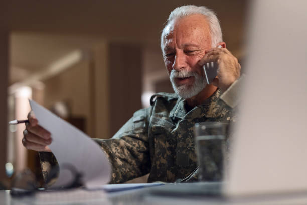 istock Senior businessman checking time on wristwatch while working in the office. 1128523793