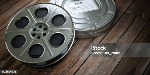 Vintage Film Reel With Filmstrip On Wood Background Video Cinema Multimedia Concept Stock Photo - Download Image Now