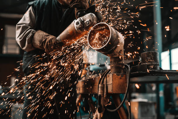 homem irreconhecível em traje de proteção e luvas, corte o tubo com moedor. interior da oficina. - grinding steel sparks cutting - fotografias e filmes do acervo