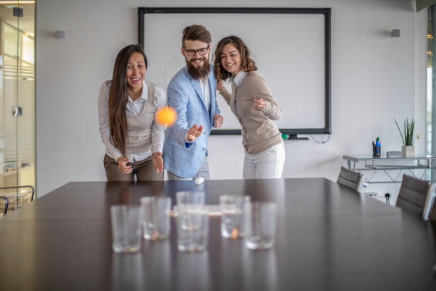 istock Young colleagues playing beer pong 1128526684