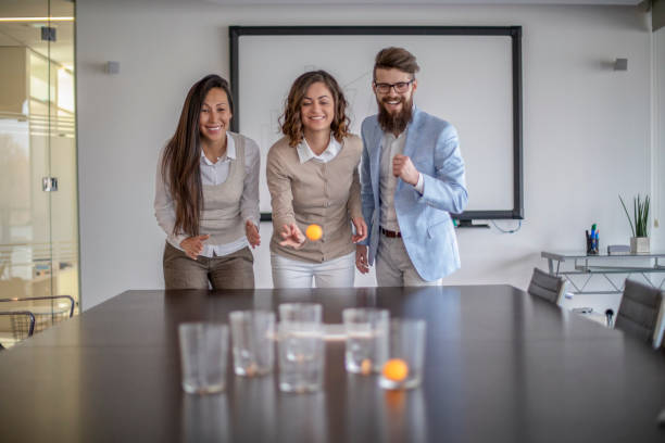 istock Young colleagues playing beer pong 1128526693