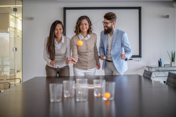 istock Young colleagues playing beer pong 1128527198