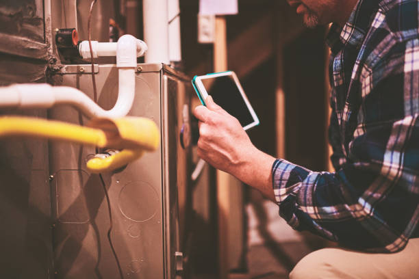istock Home Appraiser or Home Inspector using digital tablet in furnace room 1128533298