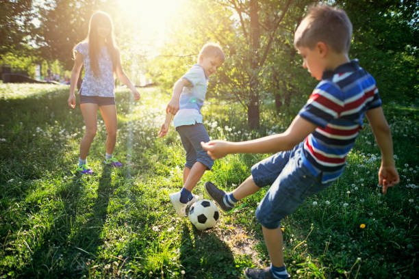 istock Kids having fun playing soccer in the park 1128537872