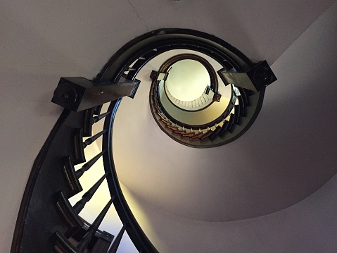 Gorgeous late 1800's dark wood curved staircase from the bottom looking up.