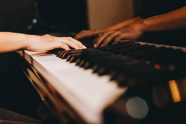 istock Close-up image of a female hands playing piano 1128537917