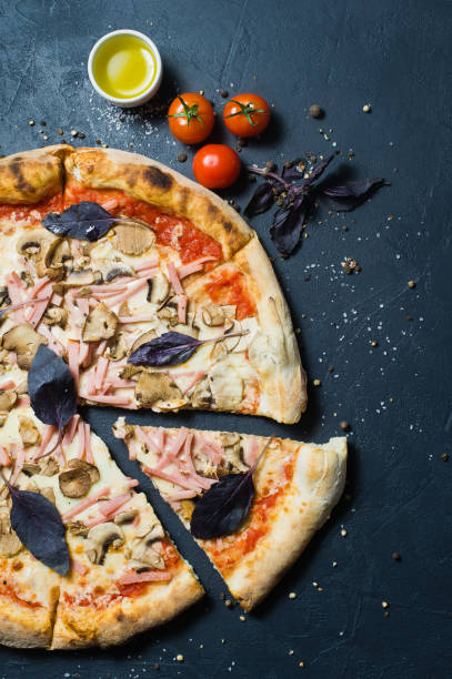 istock Freshly baked pizza with ham, mushrooms and Basil. 1128541787