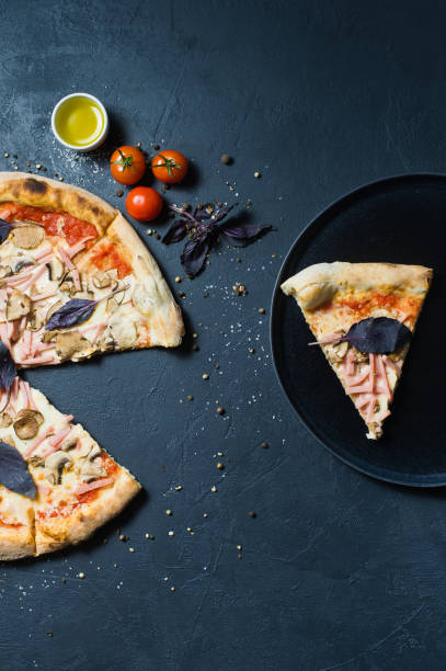 istock A slice of pizza on a black plate. 1128541815
