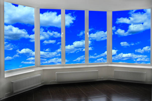 istock Window of room overlooking blue sky with white clouds. Heavenly landscape 1128541985