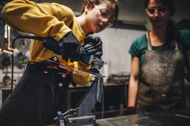 istock Sisters at a steel shop using a grinder on metal 1128542145