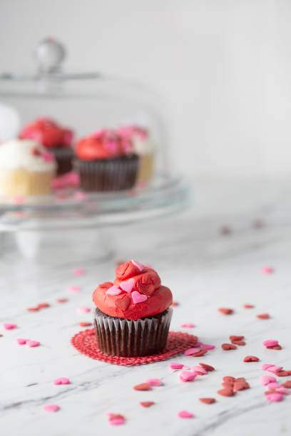 istock Valentine's Day Cupcakes on a Cake Plate with One Isolated in Front on Red Doily 1128542876
