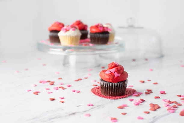 istock Valentine's Day Cupcakes on a Cake Plate with One Isolated in Front on Red Doily 1128542884