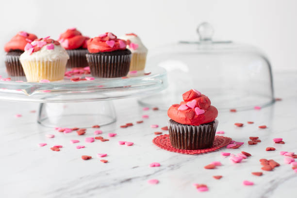 istock Valentine's Day Cupcakes on a Cake Plate with One Isolated in Front on Red Doily 1128542893