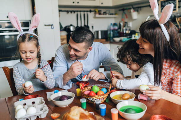 istock Happy family painting Easter eggs 1128547000