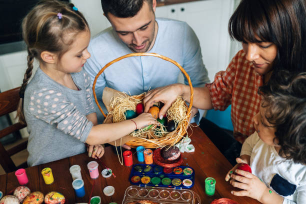 istock Happy family painting Easter eggs 1128547004
