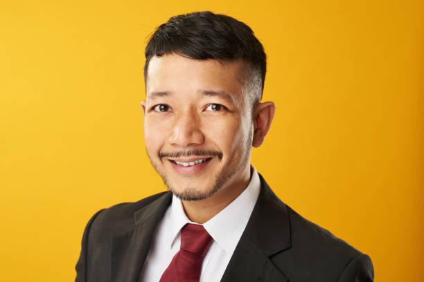 Headshot of smiling asian man Headshot of smiling asian man isolated on yellow background military invasion photos stock pictures, royalty-free photos & images