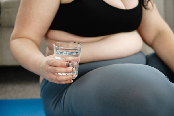 istock overweight woman rests during home yoga workout 1128553365