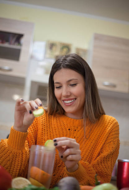 istock Smiling vegan woman making smoothie. 1128559356