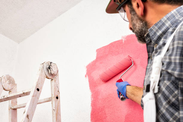 istock Professional house painter at work painting the wall 1128564574