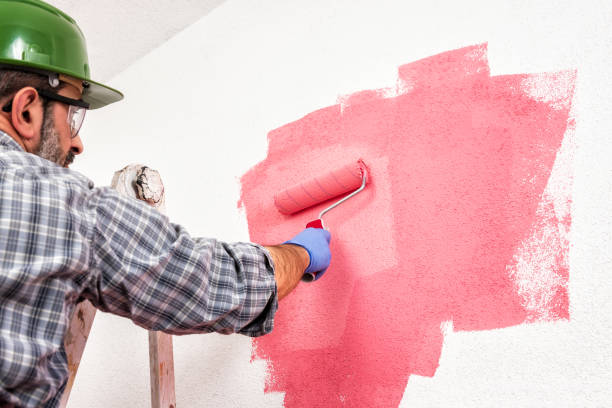 istock Professional house painter at work painting the wall 1128564577