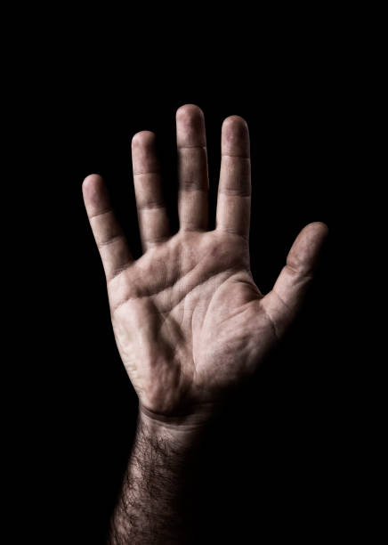 Human hand showing sign on black background.
