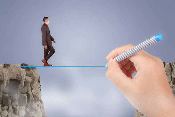 istock Businessman Walks Trough Obstacle Gap With Help By Big Mentor Leader 1128567469