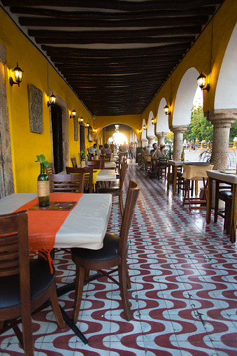 Valladolid, Yucatan, Mexico: A beautifully tiled outdoor restaurant under the Spanish colonial arches on the central square in Valladolid, Mexico. Shot at dusk.