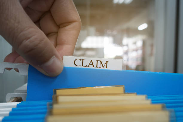 human hand is picking up the claim document in the file for the client to the insurance company.insurance concept. - insurance law insurance agent protection imagens e fotografias de stock
