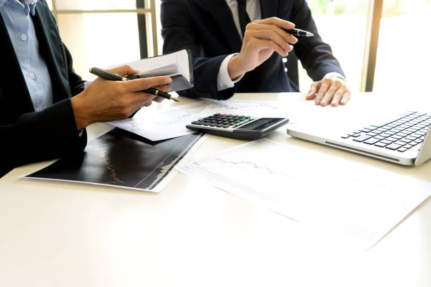 istock business man and woman sit at ther table looking at computer laptop 1128581134