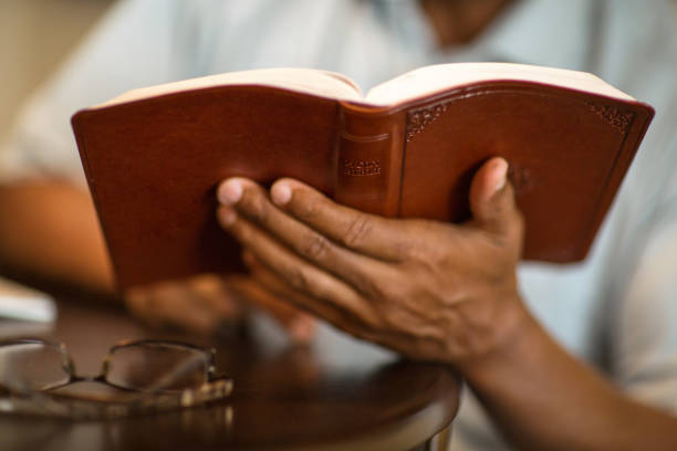 istock African American man praying and reading the Bible. 1128582668