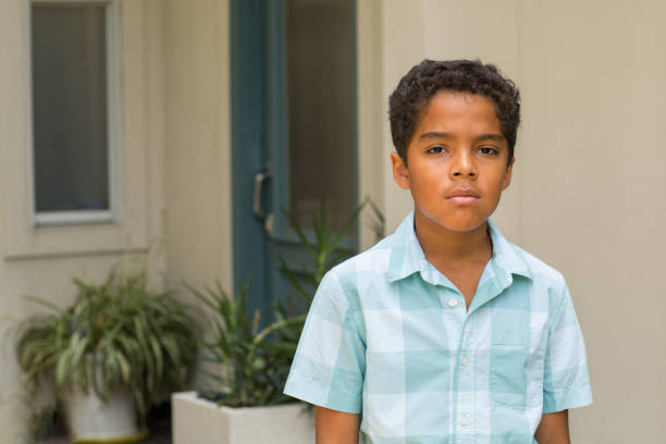 Cute African American boy wearing blue jeans and a button down, standing and smiling on a white background.http://gabrielboone.com/boone/stock/rhone.jpg