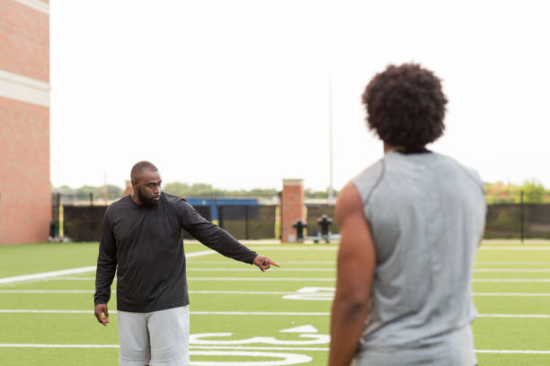 istock American Football coach training a young athlete. 1128583786
