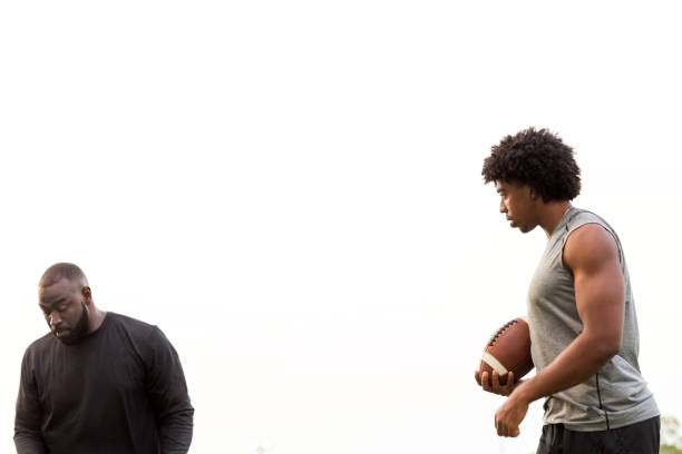istock American Football coach training a young athlete. 1128583789