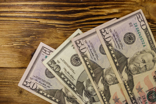 istock Fifty dollars banknotes on wooden background. Top view 1128598247