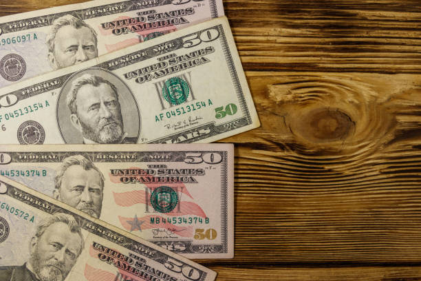 istock Fifty dollars banknotes on wooden background. Top view 1128598248