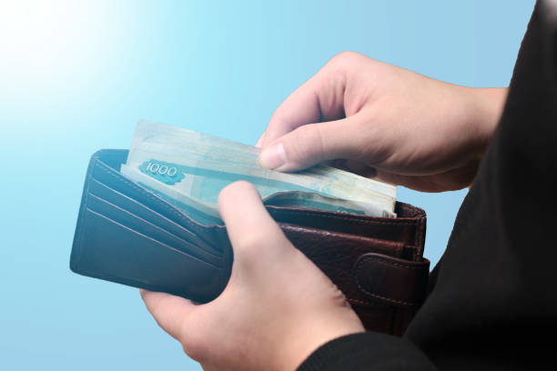istock Hands with old bills one hundred thousand rubles isolated on blue background 1128600114