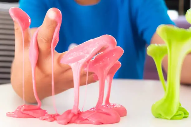Photo of Hand Holding Homemade Toy Called Slime, Kids having fun and being creative by science experiment.
