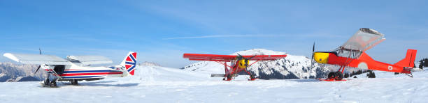 monte pora, bergamo, włochy. jednosilnikowe, lekkie samoloty zaparkowane na pokrytym śniegiem płaskowyżu. czerwone i brytyjskie kolory flagi jako barwy - scenics winter mountain range mountain zdjęcia i obrazy z banku zdjęć