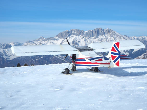 monte pora, bergamo, włochy. jednosilnikowy, lekki samolot lotniczy zaparkowany na pokrytym śniegiem płaskowyżu. uk flag kolory jako barwy - mountain landscape winter mountain range zdjęcia i obrazy z banku zdjęć