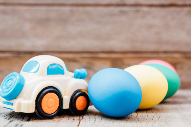 istock Easter egg and toy car on wooden background 1128609036