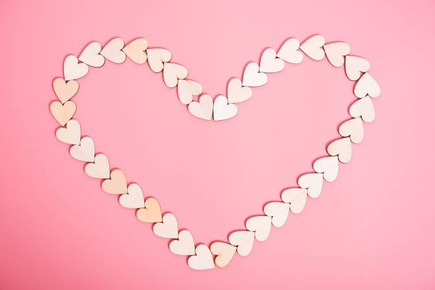 istock Wood hearts on pink background 1128609074