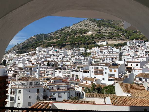 Mijas Pueblo, Spain These pictures come from Mihas Pueblo in Spain.  The city is located in Andalucía and on the side of a mountain.  All the buildings are white so it really stands out in contrast with the mountains and hill side.  There is a church there called The Church of the Rock.  It is build right in and around a mountain and most of its walls are made from the mountain.  It is very cute and the outside has a great square that overlooks the incredible ocean below.  The city has a bull ring and still does bull fighting there.  It has a few big squares where concerts are held.  There are many great restaurants there and the tourists are abundant.  = )  Its very cute and the small winding streets are amazing.  Cover with green trees and plants it really stands out and is truly amazing. mijas pueblo stock pictures, royalty-free photos & images