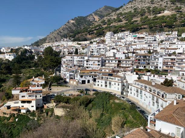 Mijas Pueblo, Spain These pictures come from Mihas Pueblo in Spain.  The city is located in Andalucía and on the side of a mountain.  All the buildings are white so it really stands out in contrast with the mountains and hill side.  There is a church there called The Church of the Rock.  It is build right in and around a mountain and most of its walls are made from the mountain.  It is very cute and the outside has a great square that overlooks the incredible ocean below.  The city has a bull ring and still does bull fighting there.  It has a few big squares where concerts are held.  There are many great restaurants there and the tourists are abundant.  = )  Its very cute and the small winding streets are amazing.  Cover with green trees and plants it really stands out and is truly amazing. mijas pueblo stock pictures, royalty-free photos & images