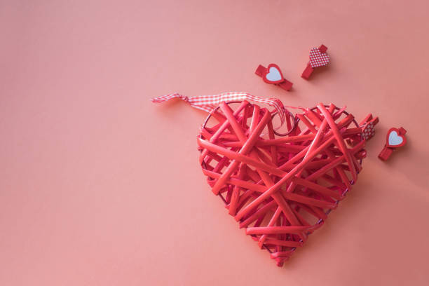 istock Valentine's day concept. Wicker heart on a coral background. field for text. 1128612803