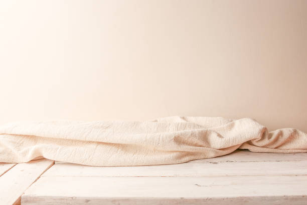 Background of white cloth on wooden planking and empty wall.